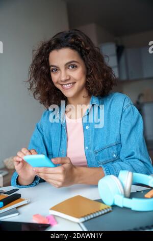 Vertical portrait of young student using smartphone app and looking at camera. Stock Photo