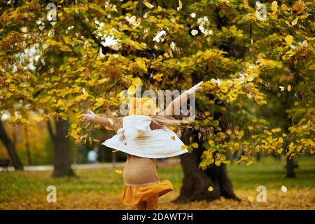 Girl in a knitted hat and scarf on a background of autumn …