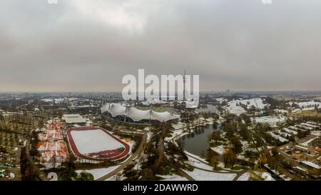 Winter in Munich, snow covered park in the heart of the bavarian metropole, a panoramic view at the olympic park with its tower and lake. Stock Photo