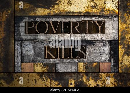 Poverty Kills text message on textured grunge copper and vintage gold background Stock Photo