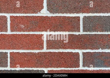 a closeup view of a red and brown brick wall with white grout displaying detail weathered horizontal retro surface pattern construction and colorful Stock Photo