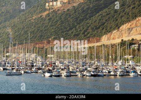 A pier with yachts on the shore during sunset. Yacht club with many sailing yachts docked in Turkey. Stock Photo