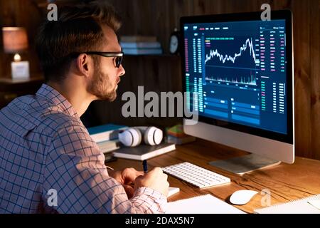 Business man trader looking at pc analyzing financial chart trading data. Stock Photo