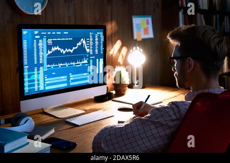 Stock market analyst looking at computer trading online analyzing data. Stock Photo