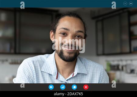 Smiling young african ethnicity guy enjoying distant communication. Stock Photo
