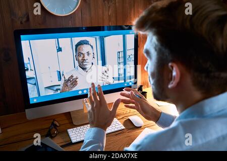 Caucasian business man talking with african partner on video conference call. Stock Photo