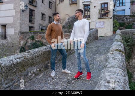 Two young friends standing on an old stone bridge and talking Stock Photo