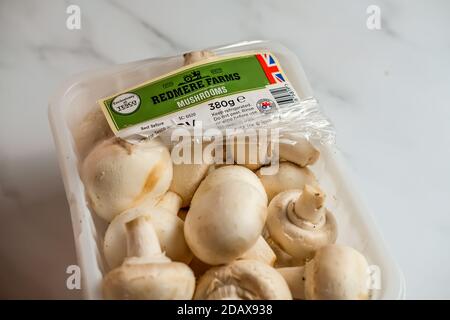 Norwich, Norfolk, UK – November 15 2020. Illustrative editorial photo of a plastic tub of Redmere Farms Mushrooms, which are exclusive to Tesco, on a Stock Photo