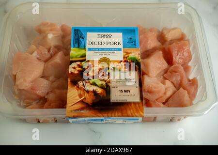 Norwich, Norfolk, UK – November 15 2020. Illustrative editorial photo of a plastic pack of Tesco diced pork on a marbled white worktop Stock Photo