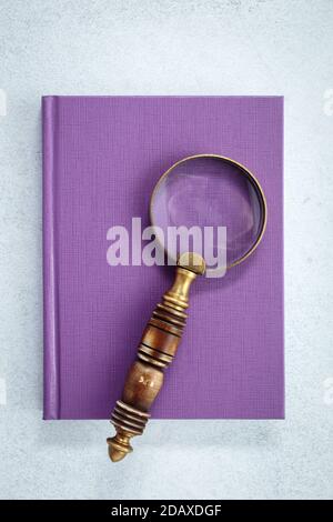 Magnifying glass on purple notebook Stock Photo