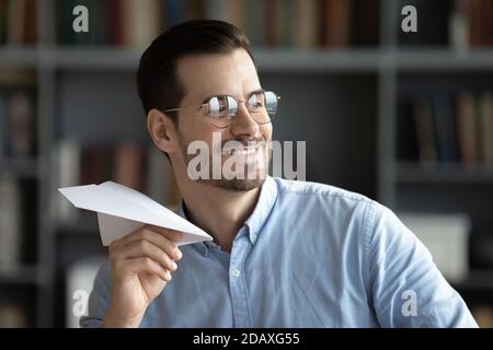 Optimistic businessman folded paper plane having fun in office Stock Photo