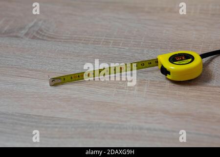 Tape measure on the table. Fifteen inches on a tape measure. Stock Photo