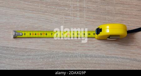 Tape measure on the table. Fifteen inches on a tape measure. The entire tape is in focus Stock Photo