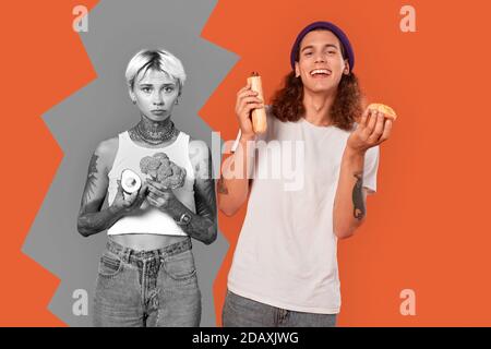 Young adult hipster man and woman holding food in hands Stock Photo