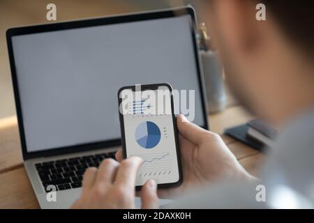 Businessman synchronize information using laptop and smartphone with financial data Stock Photo