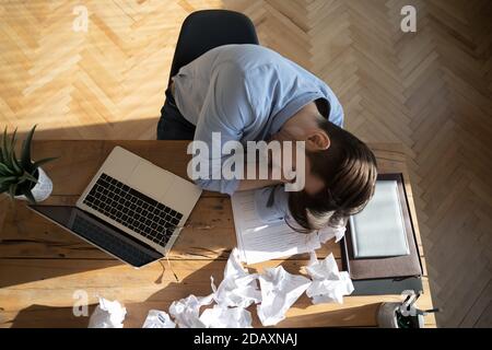 Above view tired office employee fell asleep at workplace desk. Stock Photo