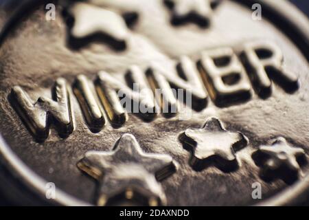 Macro closeup of a gold medal with the word winner on it. Concept for success, motivation and achievement Stock Photo