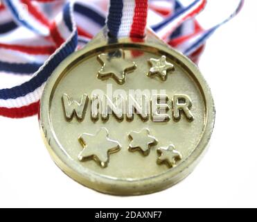 A gold medal with the word winner on it, isolated on a white background. Success and achievement concept. Stock Photo