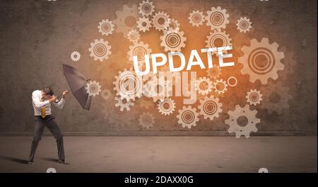 Businessman defending with umbrella from UPDATE inscription, technology concept Stock Photo