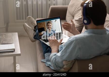 Relaxed young guy enjoying fun online talk with male buddy. Stock Photo