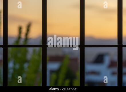 View behind the window bars at home due to the coronavirus pandemic Stock Photo