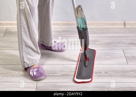 Cleaning room using mop with microfiber cloth and special liquid by house worker. Stock Photo