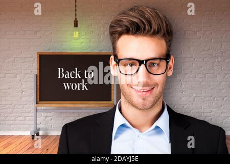 young businessman in front of chalkboard with message BACK TO WORK Stock Photo