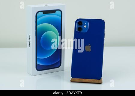 iPhone 12 in blue next to its box. Stock Photo