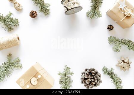 Christmas composition on white surface. Handmade gift boxes, christmas decorations, fir branches, pine cones. Handmade DIY concept. Flat lay, top view Stock Photo