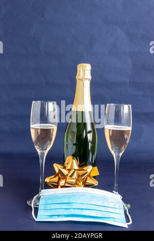 New year 2021 champagne bottle and glasses with face mask for prevention against coronavirus pandemic Stock Photo