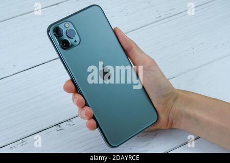 iPhone 11 Pro Max in midnight green in the hand of a customer. Stock Photo