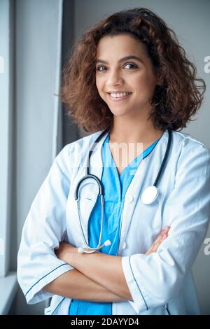 Vertical portrait of young female doctor wear smiling and looking at camera. Stock Photo