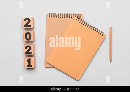 Notebooks with figure 2021 and pencil on light background Stock Photo