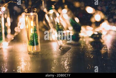 https://l450v.alamy.com/450v/2db0c1y/christmas-still-life-with-small-christmas-trees-in-glass-jars-and-glowing-holiday-lights-2db0c1y.jpg