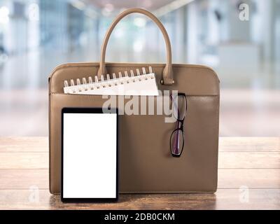 Mock Up Digital Tablet pc With blank screen. Workspace with Bag, business briefcase, mockup blank digital tablet on wooden office table Stock Photo