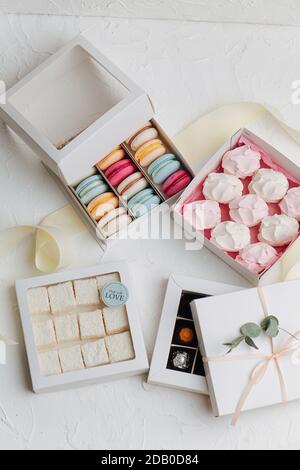 Lots of sweets in square boxes. Macarons, turkish delight, zefir, wrapped candy Stock Photo
