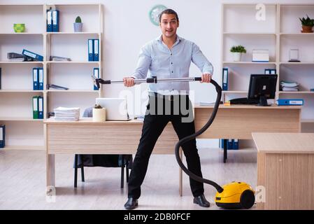 Young employee businessman cleaning office during pandemic Stock Photo