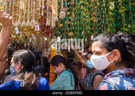 Street scene of Indian women choosing decorative items hanging on top. Singapore. 2020 Stock Photo