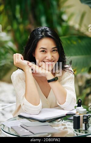 Lovely young woman sitting at table Stock Photo