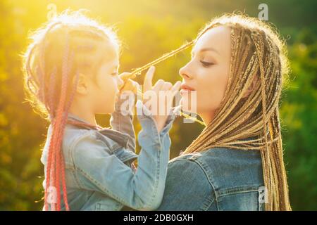 Mother and daughter with braiding hair. Nice child girl with plaits. Hair in trendy weave plait Stock Photo