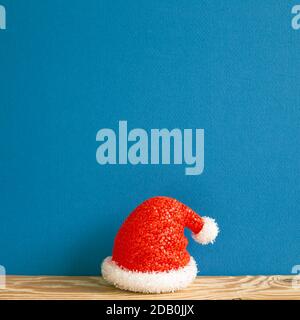 Christmas concept. Santa claus hat on wooden table with blue background Stock Photo