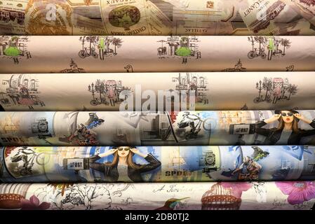 Rolled up rolls of vinyl wallpaper in a building supermarket, shop. Colorful wallpaper for the wall, decorative materials for the renovation of a room Stock Photo