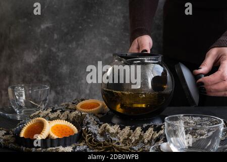 Woman hands pouring tea from  a teapot Stock Photo