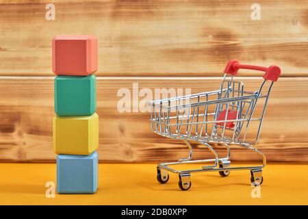 empty wooden cubes mockup style, copy space with shopping trolleys on wooden background. Colourful blocks template for creative design, place for text Stock Photo