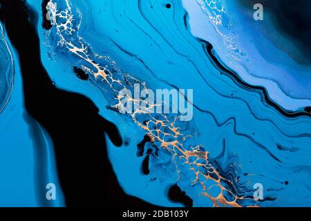 Fluid Art. Liquid Metallic Gold in abstract blue wave. Marble effect background or texture Stock Photo