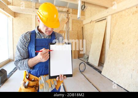 Worker showing document at construction site area, blank copy space for text Stock Photo