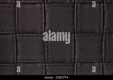 Texture of dark black leather background with square pattern and stitch, macro. Abstract backdrop from modern decorative textile with geometric shape. Stock Photo