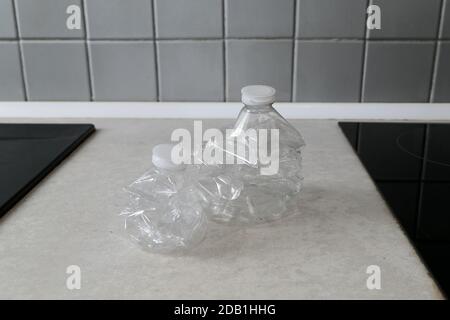 Empty plastic bottles crushed and compressed for recycling. Garbage recycling concept in a kitchen. Stock Photo