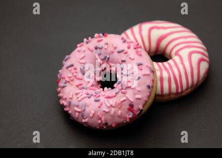 Two pink donuts on a dark background Stock Photo