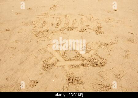 Star of David drawn on the sand beach in Tel Aviv, Israel and over it the name of God in Hebrew (Jehovah) is written. Stock Photo